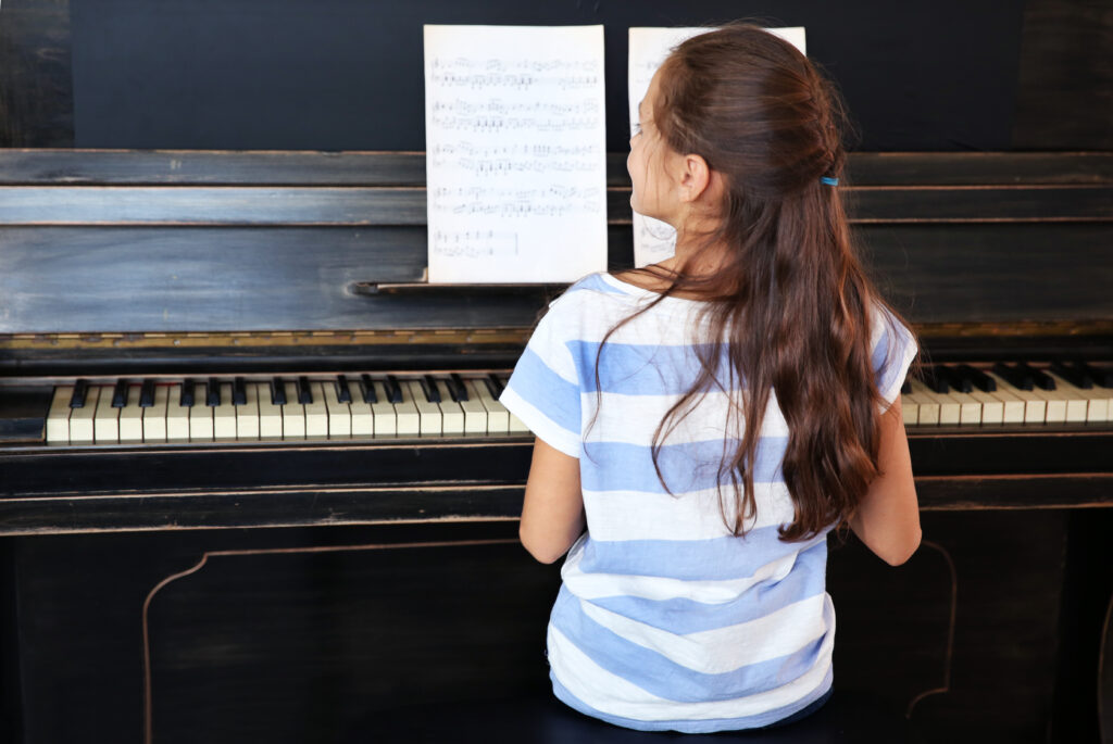 Mädchen übt konzentriert am Klavier