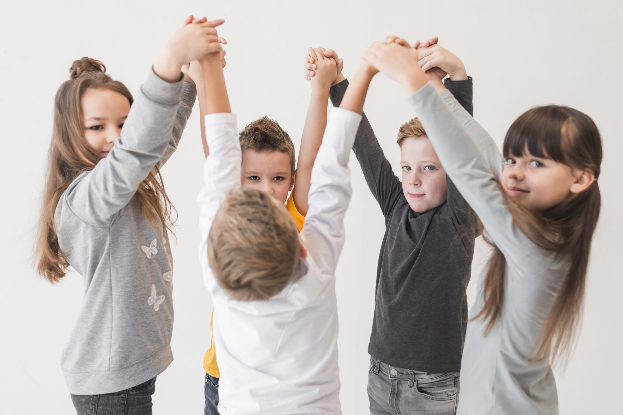 Eine Kindergruppe von Kindern fässt sich an den Händen und bewegt sich gemeinsam zur Musik