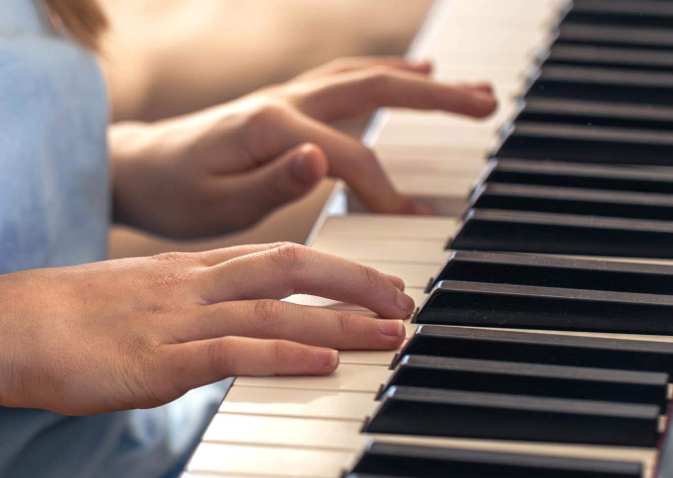 Hände die an einem Klavier spielen