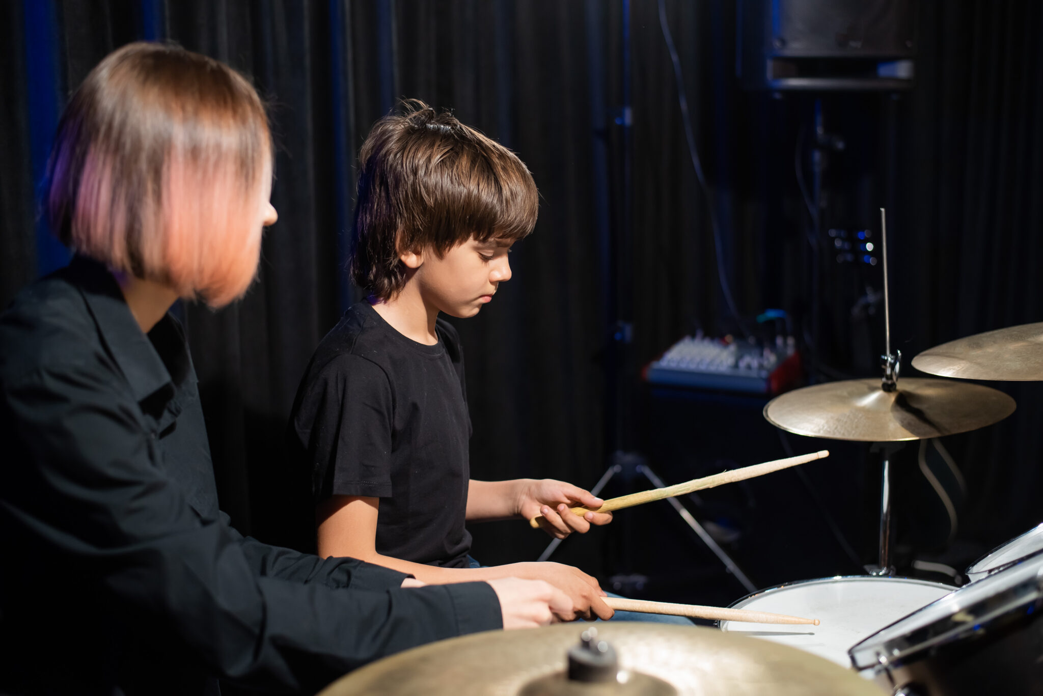 Junge und Lehrerin beim Schlagzeugunterricht