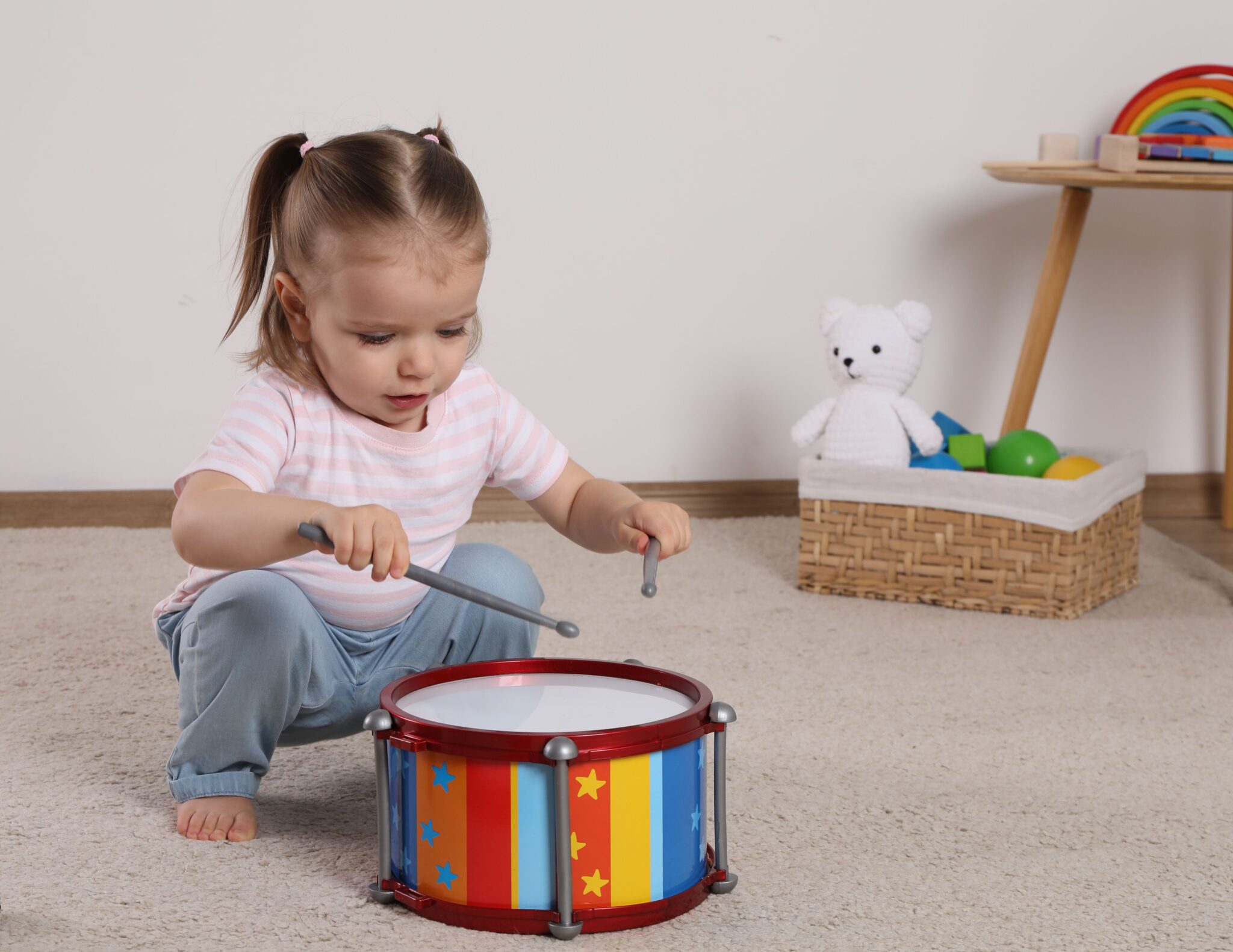 Ein Kleinkind entdecken spielerisch eine bunte kleine Trommel